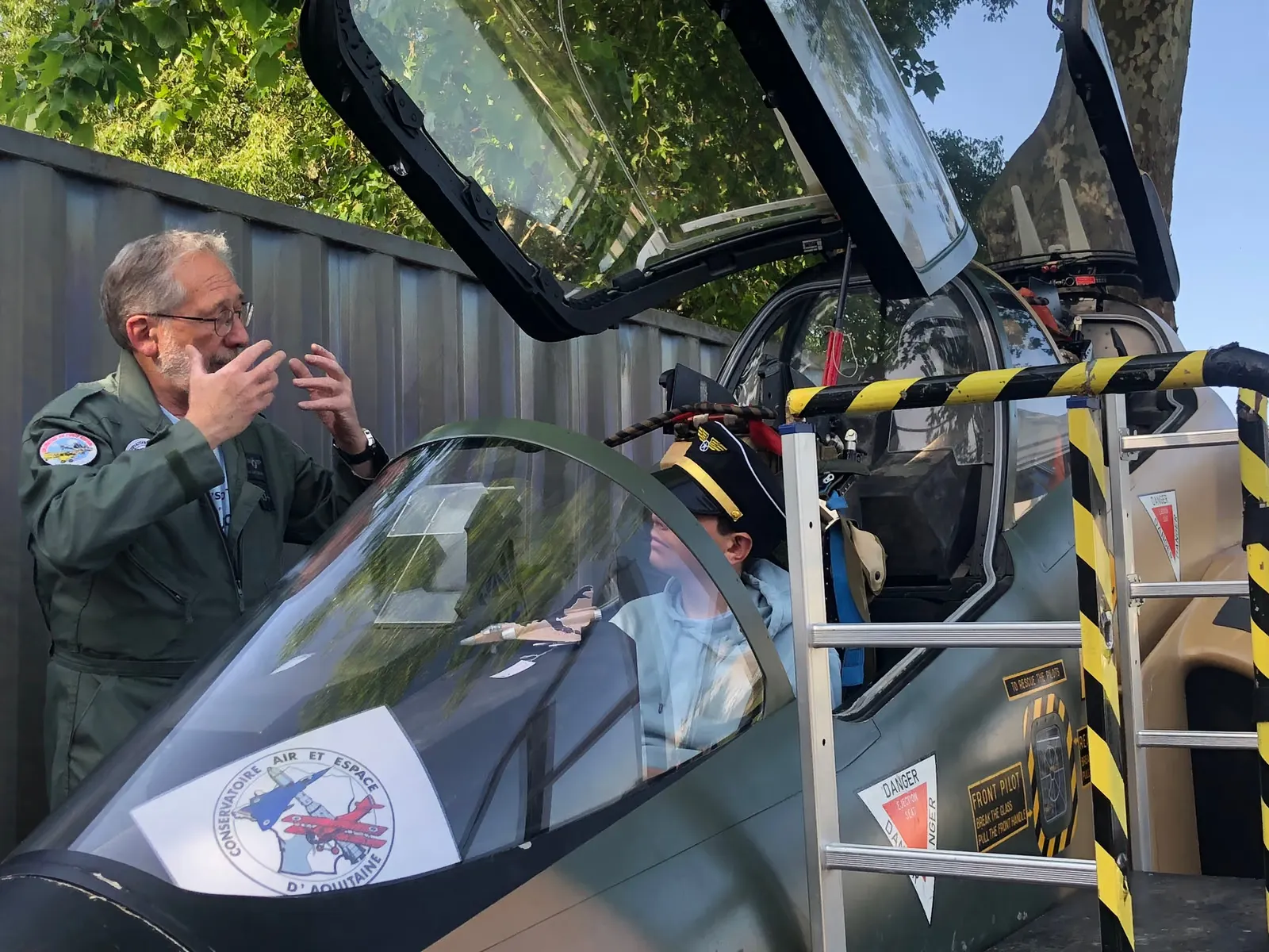 Un pilote présente le cockpit de l'Alphajet à un jeune visiteur, édition 2023